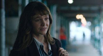 Movie still from “She Said” (2022), directed by Maria Schrader – A young woman is standing in a hallway; Close Up shot, Over the shoulder angle