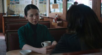 Movie still from “She Said” (2022), directed by Maria Schrader – Two women sitting at a table with a cup of coffee; Medium shot, Over the shoulder angle