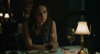 Movie still from “She Said” (2022), directed by Maria Schrader – A woman sitting at a table with a glass of red wine; Close Up shot, Over the shoulder angle