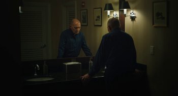 Movie still from “She Said” (2022), directed by Maria Schrader – An older man looking in the bathroom mirror; Medium shot, Low angle