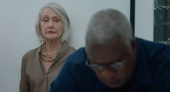 Movie still from “She Said” (2022), directed by Maria Schrader – An older woman and a younger man are looking at each other; Close Up shot, Over the shoulder angle