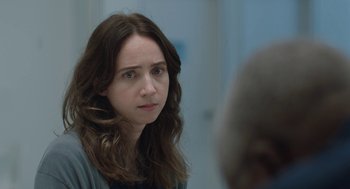 Movie still from “She Said” (2022), directed by Maria Schrader – A woman with long brown hair stares into the camera; Close Up shot, Over the shoulder angle