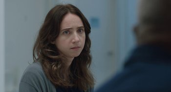 Movie still from “She Said” (2022), directed by Maria Schrader – A person with long brown hair; Close Up shot, Over the shoulder angle