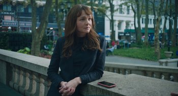 Movie still from “She Said” (2022), directed by Maria Schrader – A woman sitting on a ledge with a cell phone in front of her; Close Up shot, Over the shoulder angle