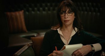 Movie still from “She's Funny That Way” (2014), directed by Peter Bogdanovich – A woman sitting in a chair holding a notepad; Close Up shot, High angle