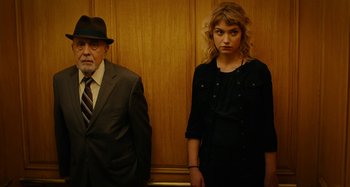 Movie still from “She's Funny That Way” (2014), directed by Peter Bogdanovich – An older man and a young woman standing next to each other; Medium shot, Low angle