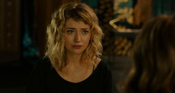 Movie still from “She's Funny That Way” (2014), directed by Peter Bogdanovich – A beautiful young woman with blonde hair wearing a black shirt; Close Up shot, Over the shoulder angle