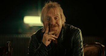 Movie still from “She's Funny That Way” (2014), directed by Peter Bogdanovich – A man in a leather jacket with his finger in his mouth; Close Up shot, High angle