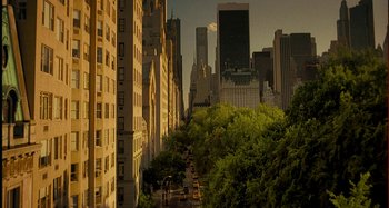 Movie still from “She's Funny That Way” (2014), directed by Peter Bogdanovich – A view of a street with trees and buildings in the background; Extreme Wide shot, High angle