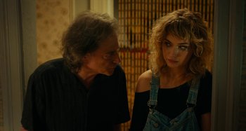 Movie still from “She's Funny That Way” (2014), directed by Peter Bogdanovich – A man and a woman standing next to each other; Close Up shot, Over the shoulder angle