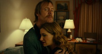 Movie still from “She's Funny That Way” (2014), directed by Peter Bogdanovich – A man and a woman hugging in a living room; Close Up shot, Low angle