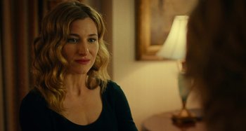 Movie still from “She's Funny That Way” (2014), directed by Peter Bogdanovich – A woman in a black shirt is smiling for the camera; Close Up shot, Over the shoulder angle