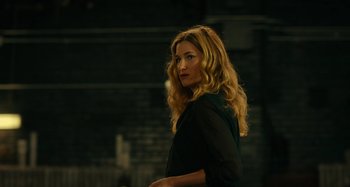 Movie still from “She's Funny That Way” (2014), directed by Peter Bogdanovich – A woman with long blonde hair wearing a black shirt; Medium shot, Over the shoulder angle