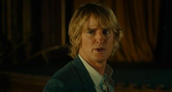 Movie still from “She's Funny That Way” (2014), directed by Peter Bogdanovich – A person wearing a suit and tie; Close Up shot, Over the shoulder angle