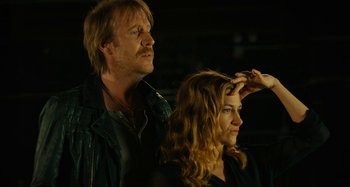 Movie still from “She's Funny That Way” (2014), directed by Peter Bogdanovich – A man and a woman standing next to each other; Medium shot, Low angle