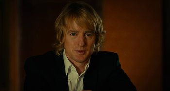 Movie still from “She's Funny That Way” (2014), directed by Peter Bogdanovich – A person wearing a suit and tie; Close Up shot, Over the shoulder angle