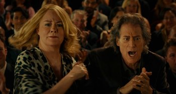 Movie still from “She's Funny That Way” (2014), directed by Peter Bogdanovich – A woman and a man in front of an audience; Medium shot, Over the shoulder angle