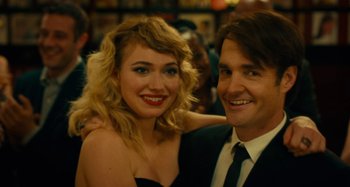 Movie still from “She's Funny That Way” (2014), directed by Peter Bogdanovich – A man and a woman posing for a picture; Close Up shot, Over the shoulder angle