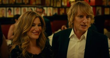 Movie still from “She's Funny That Way” (2014), directed by Peter Bogdanovich – A man and a woman standing next to each other; Close Up shot, Over the shoulder angle