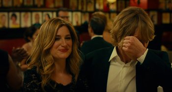 Movie still from “She's Funny That Way” (2014), directed by Peter Bogdanovich – A man and a woman standing next to each other in a room; Close Up shot, Over the shoulder angle