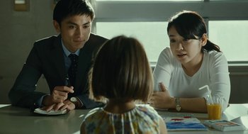 Movie still from “Shoplifters” (2018), directed by Kore-eda Hirokazu – A group of people sitting around a table; Medium shot, Over the shoulder angle