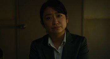 Movie still from “Shoplifters” (2018), directed by Kore-eda Hirokazu – A woman wearing a suit and a striped shirt; Close Up shot, Low angle