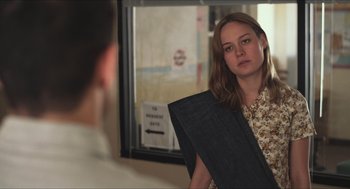 Movie still from “Short Term 12” (2013), directed by Destin Daniel Cretton – A young woman holding an umbrella in front of a mirror; Medium shot, Over the shoulder angle