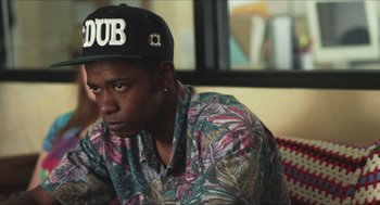 Movie still from “Short Term 12” (2013), directed by Destin Daniel Cretton – A young man wearing a hat and a floral shirt; Close Up shot, Over the shoulder angle