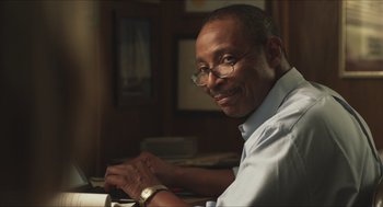 Movie still from “Short Term 12” (2013), directed by Destin Daniel Cretton – An older man wearing glasses sitting at a table; Close Up shot, Low angle