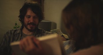 Movie still from “Short Term 12” (2013), directed by Destin Daniel Cretton – A man and a woman sitting on a couch looking at a book; Close Up shot, Over the shoulder angle