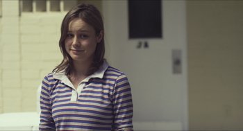 Movie still from “Short Term 12” (2013), directed by Destin Daniel Cretton – A woman in a striped shirt is standing in front of a wall; Close Up shot, Over the shoulder angle