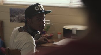 Movie still from “Short Term 12” (2013), directed by Destin Daniel Cretton – A man with headphones sitting in front of a laptop; Close Up shot, Over the shoulder angle