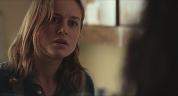 Movie still from “Short Term 12” (2013), directed by Destin Daniel Cretton – A young woman looking at the camera with a serious look on her face; Close Up shot, Over the shoulder angle