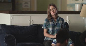 Movie still from “Short Term 12” (2013), directed by Destin Daniel Cretton – A woman sitting on a couch in a living room; Medium shot, Over the shoulder angle