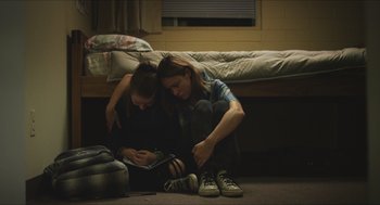 Movie still from “Short Term 12” (2013), directed by Destin Daniel Cretton – Two young women sitting on the floor looking at a tablet; Medium shot, High angle