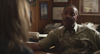 Movie still from “Short Term 12” (2013), directed by Destin Daniel Cretton – A man sitting at a table in front of papers; Close Up shot, Over the shoulder angle
