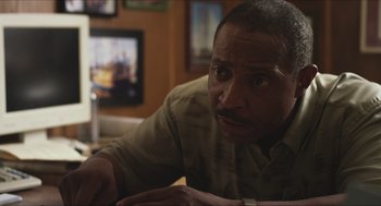Movie still from “Short Term 12” (2013), directed by Destin Daniel Cretton – A man sitting at a table looking at the camera; Close Up shot, Over the shoulder angle