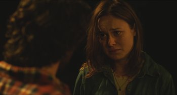 Movie still from “Short Term 12” (2013), directed by Destin Daniel Cretton – A young woman with long brown hair is looking at the camera; Close Up shot, Over the shoulder angle