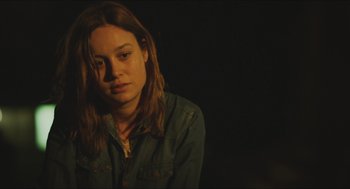 Movie still from “Short Term 12” (2013), directed by Destin Daniel Cretton – A woman sitting in a dark room with her eyes closed; Close Up shot, Over the shoulder angle