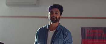 Movie still from “Oh Manapenne” (2021), directed by Kaarthikk Sundar – A man with a beard is smiling for the camera; Close Up shot, Low angle