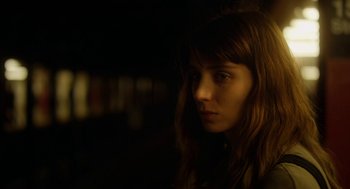 Movie still from “Side Effects” (2013), directed by Steven Soderbergh – A woman with long brown hair stares into the distance; Close Up shot, Over the shoulder angle
