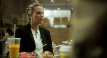 Movie still from “Side Effects” (2013), directed by Steven Soderbergh – A woman sitting at a table in a room; Close Up shot, Over the shoulder angle