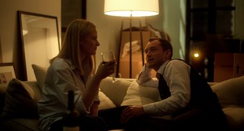 Movie still from “Side Effects” (2013), directed by Steven Soderbergh – A man and a woman sitting in a living room drinking wine; Medium shot, Over the shoulder angle
