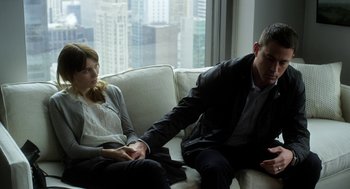 Movie still from “Side Effects” (2013), directed by Steven Soderbergh – A man and a woman sitting on a white couch; Medium shot, High angle