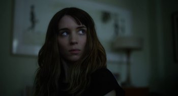 Movie still from “Side Effects” (2013), directed by Steven Soderbergh – A woman with long hair and a black shirt looking up; Close Up shot, Over the shoulder angle
