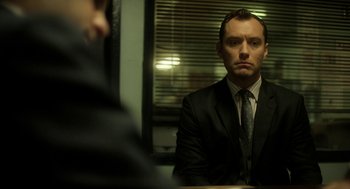 Movie still from “Side Effects” (2013), directed by Steven Soderbergh – A man in a suit and tie sitting in front of a mirror; Medium shot, Over the shoulder angle