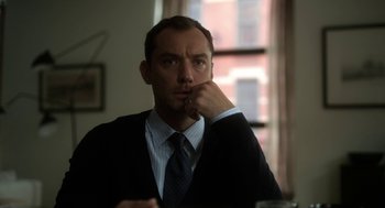 Movie still from “Side Effects” (2013), directed by Steven Soderbergh – A man in a suit and tie sitting at a table; Close Up shot, Low angle