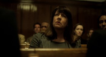 Movie still from “Side Effects” (2013), directed by Steven Soderbergh – A woman sitting in front of other people in a courtroom; Close Up shot, Low angle
