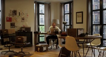Movie still from “Side Effects” (2013), directed by Steven Soderbergh – A man sitting at a desk with a laptop; Wide shot, High angle