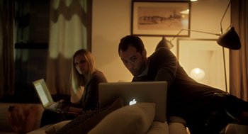 Movie still from “Side Effects” (2013), directed by Steven Soderbergh – A man and a woman sitting in front of an open laptop computer; Medium shot, High angle